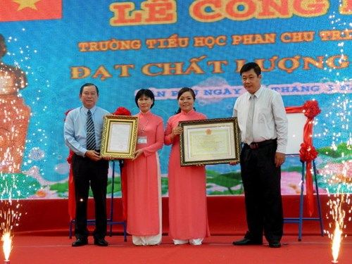 Ông Hồ Phú Bạc - Trưởng phòng Khảo thí và kiểm định chất lượng (Sở GD&ĐT TPHCM) và ông Trần Văn Phúc – Phó Chủ tịch UBND quận Tân Phú trao quyết định, giấy chứng nhận đạt chuẩn kiểm định chất lượng cho lãnh đạo nhà trường.  