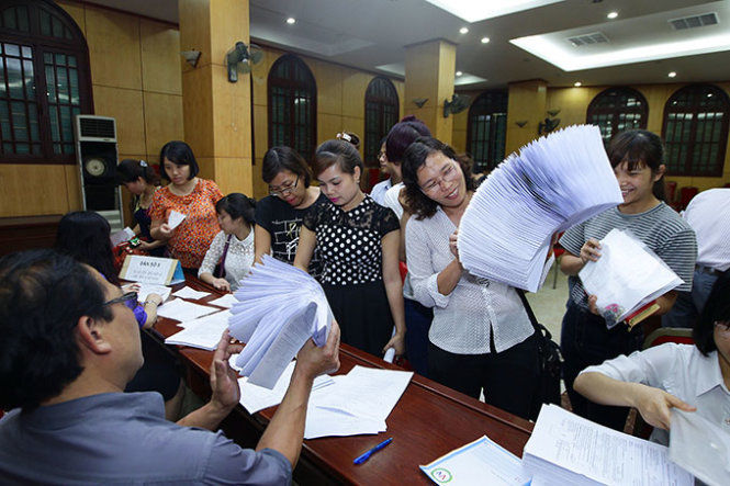 Đại diện của các cơ sở giáo dục đang tiếp nhận hồ sơ thi THPT Quốc gia năm 2015 tại Sở GD&ĐT Hà Nội chiều ngày 6-4 - Ảnh: Nguyễn Khánh