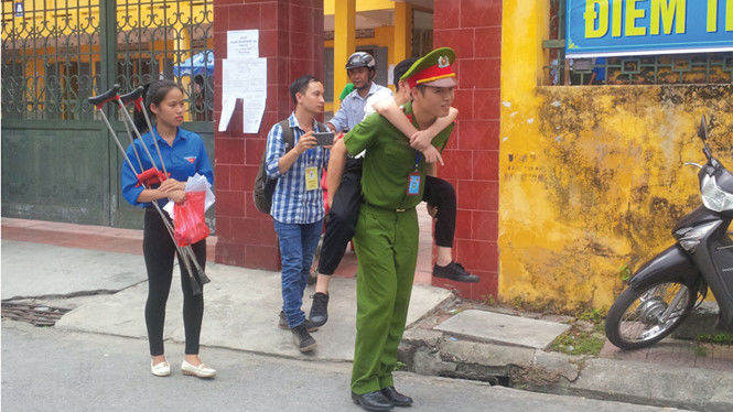 Chàng sinh viên mặc cảnh phục cõng thí sinh vào phòng thi Chàng sinh viên mặc cảnh phục cõng thí sinh vào phòng thi